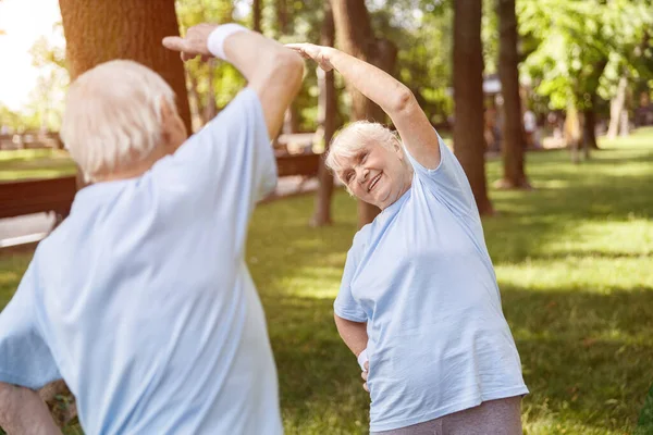Glückliches Senioren-Ehepaar trainiert im Sommer gemeinsam im malerischen Stadtpark — Stockfoto