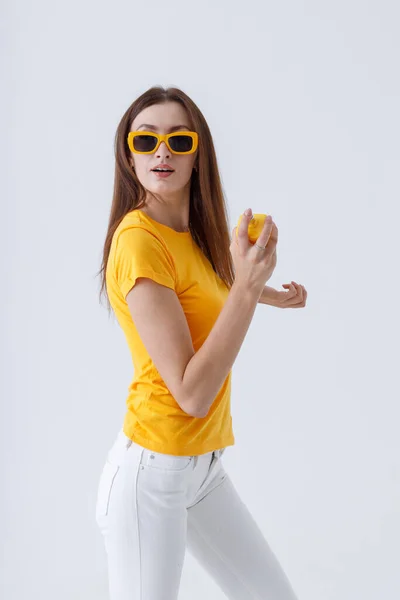 Elbűvölő nő elegáns napszemüveg kezében parfüm — Stock Fotó