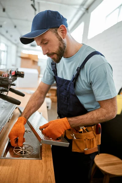 Reparador fixando máquina de café profissional no café — Fotografia de Stock