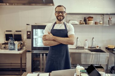 Kafede dikilen önlüklü neşeli adam