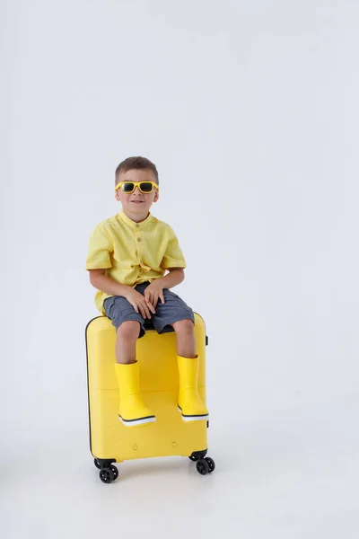 Чарівний хлопчик мандрівник сидить на дорожній сумці — стокове фото