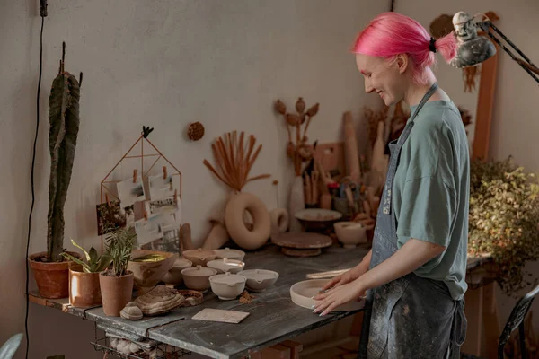 Giovane ceramista femminile impegnata nell'artigianato nel suo laboratorio — Foto Stock