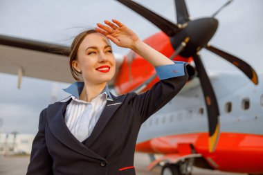 Havaalanının önünde duran neşeli kadın hostes.