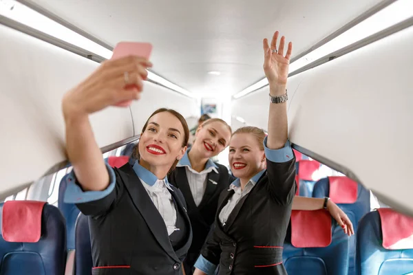 Alegre mujeres azafatas haciendo selfie en avión — Foto de Stock