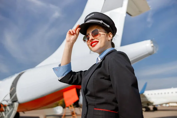 Veselá žena letuška stojící venku na letišti — Stock fotografie