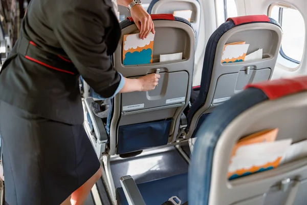 Samica stewardessy przygotowująca broszurę instruktażową dla pasażerów — Zdjęcie stockowe