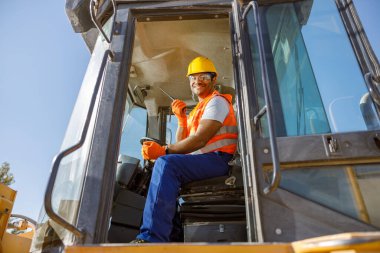 Fabrikada yük kamyonu süren el işi işçi.