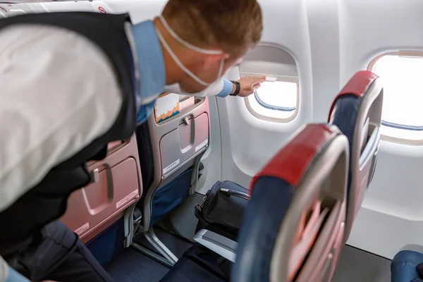 Mężczyzna stewardessa zamykająca okno w samolocie — Zdjęcie stockowe