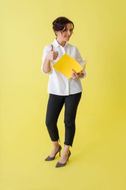 Evrakları tutan ve onaylayan neşeli bir kadın.