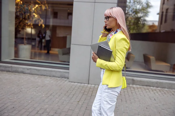 Female pedestrian speaking on mobile phone on her way — Stockfoto