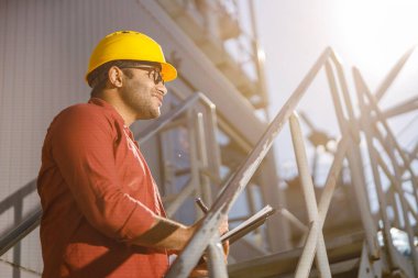 Afrikalı erkek mühendis inşaat tesisinde inceleme yapıyor.