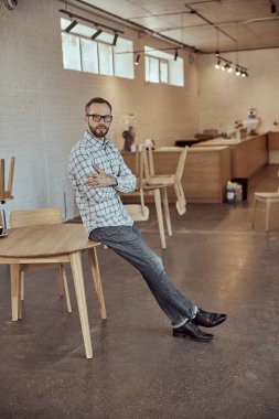 Kafede masanın kenarında oturan sakallı adam.