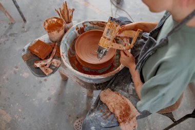 Çömlek atölyesinde kase yapan çalışkan bir zanaatkar.