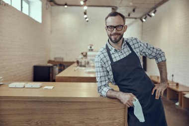 Ahşap tezgahın yanında duran neşe dolu kafe