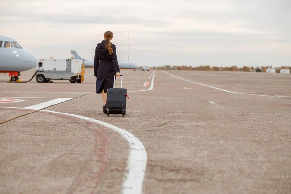Kobieta z walizką podróżną spacerująca po lotnisku — Zdjęcie stockowe