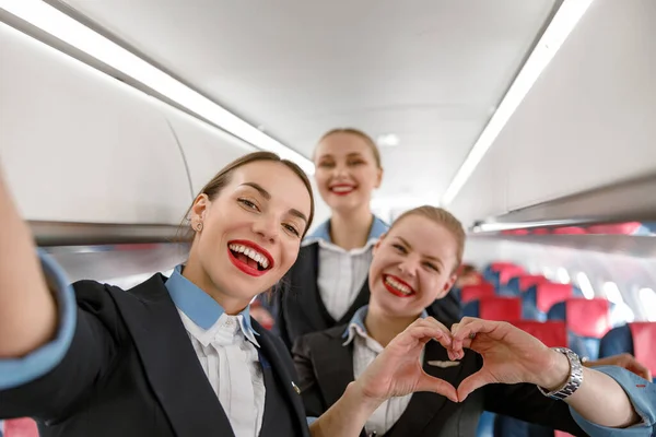 Cheerful flight attendants having fun in airplane — Stockfoto