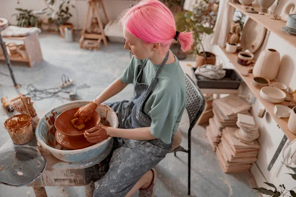 Female crafter making clay dishes in pottery room — Fotografia de Stock