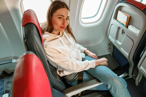 Female traveler sitting in passenger chair in airplane — Foto de Stock