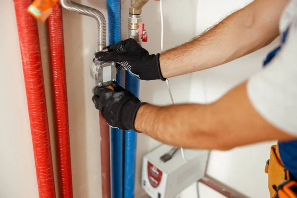 Nahaufnahme von Klempnerhänden, die Rohre reparieren, während Heizungsanlage in Wohnung installiert wird — Stockfoto