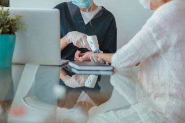 Sağlık uzmanı evde yaşlı bir hastayı kontrol ediyor.