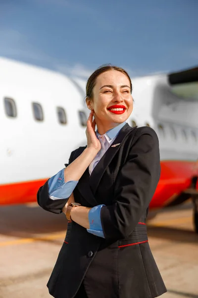 Asistente de vuelo mujer alegre de pie al aire libre en el aeródromo — Foto de Stock