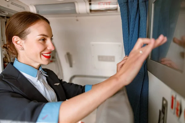 Radostná letuška používající dotykový displej v letadle — Stock fotografie