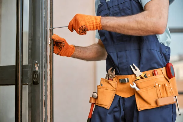 Mužské ruce v rukavicích oprava dveří v domě — Stock fotografie