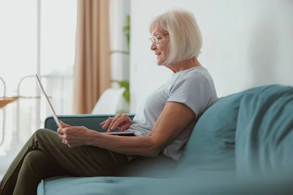 Wanita tua modern menggunakan komputer laptop di rumah — Stok Foto