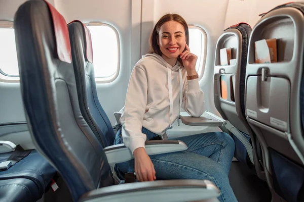 Jovencita alegre sentada en avión de pasajeros — Foto de Stock