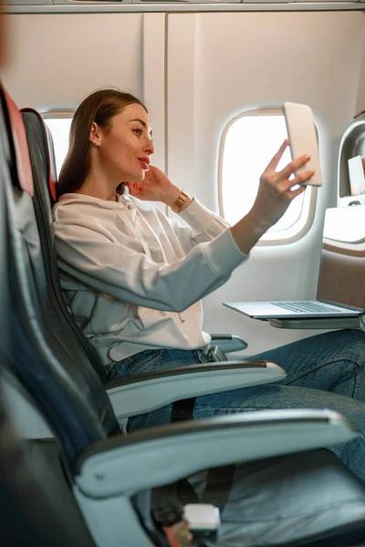Mujer joven haciendo selfie en avión de pasajeros — Foto de Stock