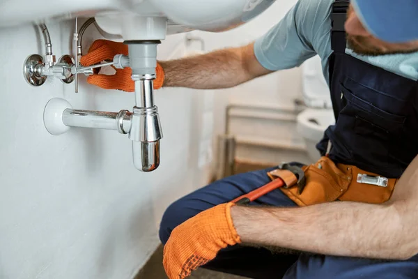 Pria tangan tukang ledeng memperbaiki pipa di bawah wastafel — Stok Foto