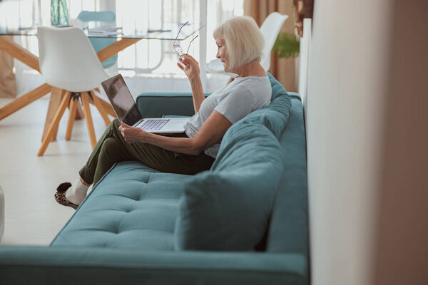 Senior woman using laptop while sitting at home