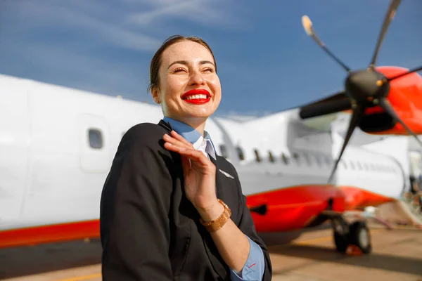 Veselá pracovnice aerolinek stojí venku na letišti — Stock fotografie