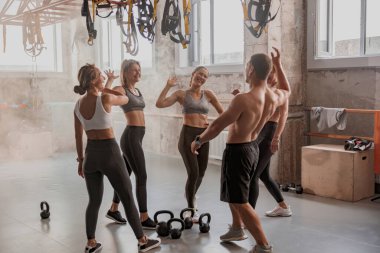 Gençler spor salonunda antrenman yapıyor.