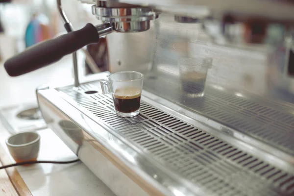 커피 머신 위에 서 있는 커피와 함께 유리잔을 클로즈업 — 스톡 사진