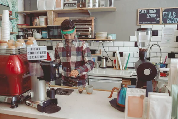 Masculino barista trabalhando no café em viseira protetora — Fotografia de Stock