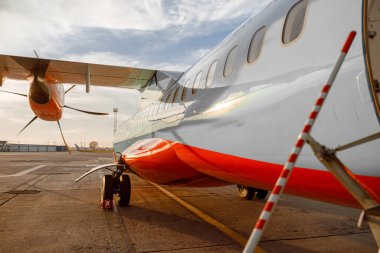 Havaalanında bulutlu gökyüzünün altında yolcu uçağı