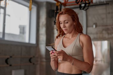 Genç ve çekici bir kadın spor salonunda mola veriyor.