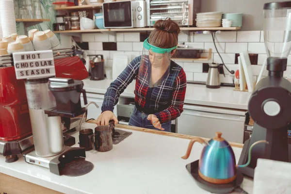 Mulher em viseira protetora usando arruela no café — Fotografia de Stock