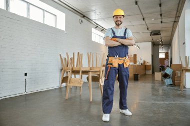 Çalışan neşeli adam atölyede duruyor.