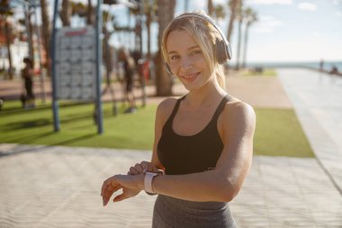 Genç bir kadın yaz günü spor için içeri giriyor.