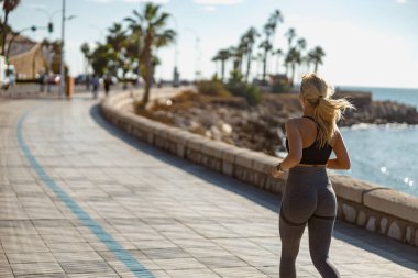 Genç bayan sporcu dışarıda antrenman yapıyor.