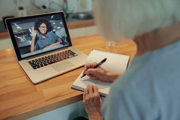 Starší žena s webkamerou volání na notebook uvnitř — Stock fotografie