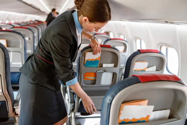 Asistente de vuelo femenina preparando folleto de instrucciones para pasajeros — Foto de Stock