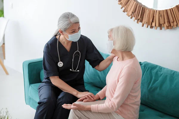 Médico adulto hablando con anciana opuesta — Foto de Stock