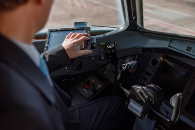 Pilot kokpitte oturuyor ve uçuş ekranını kullanıyor.