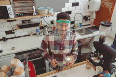 Kahveci portresi köpüklü süt deseni yapıyor.