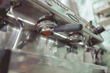 Kahve makinesinin filtresinden kahve yağı damlıyor.