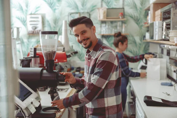 Homem barista trabalhando em café perto moedor de café — Fotografia de Stock
