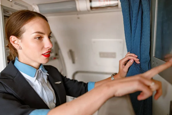 Letuška používající dotykový displej v letadle — Stock fotografie